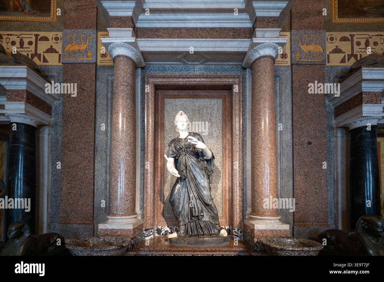 Rome, Italy - Aug 29, 2025: Interior wall niche with classical statue framed by red granite columns and marble inlays at Galleria Borghese museum, Rom Stock Photo