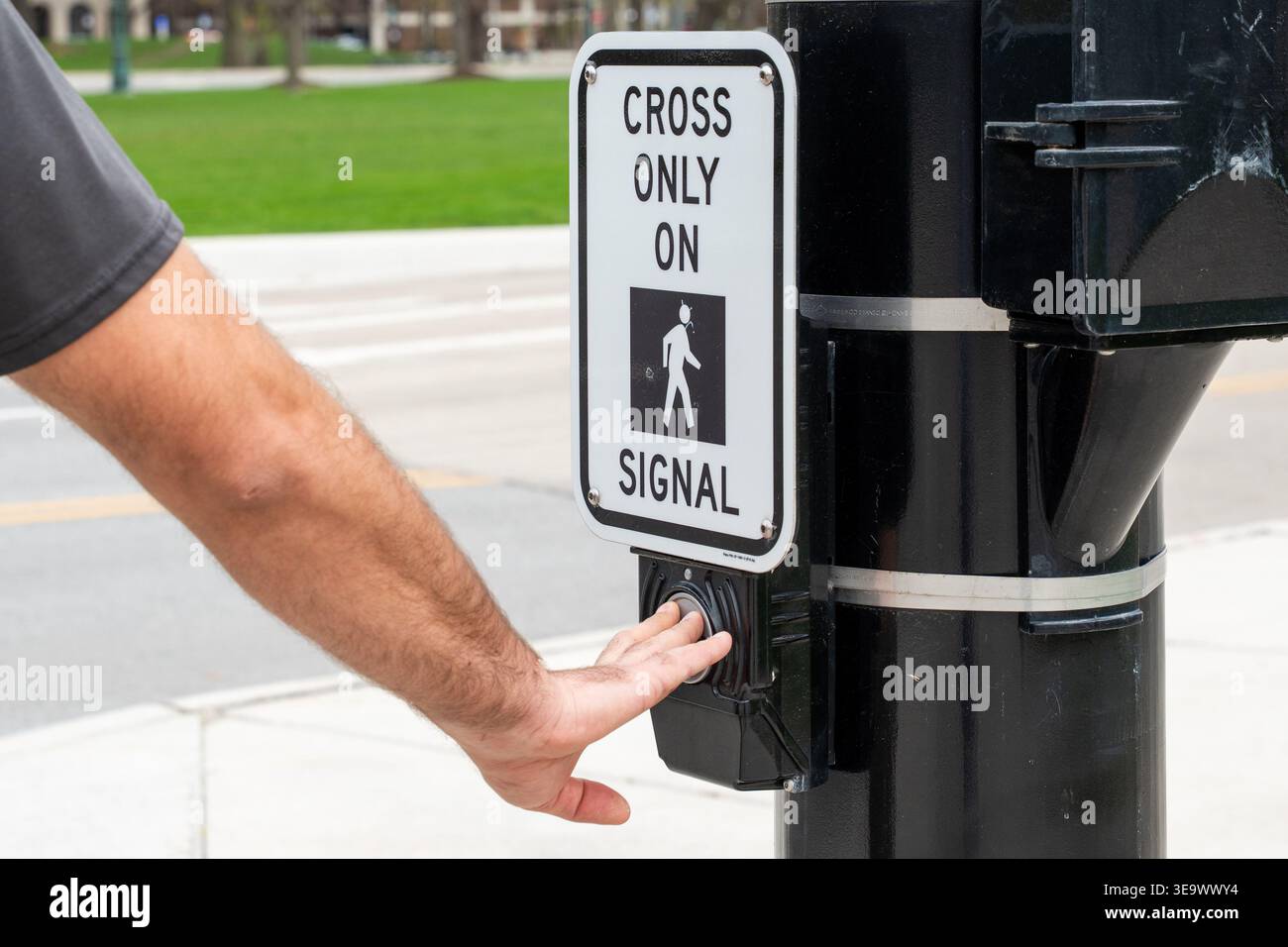 Horizontal photo of a hand pressing the pedestrian crossing button at a ...