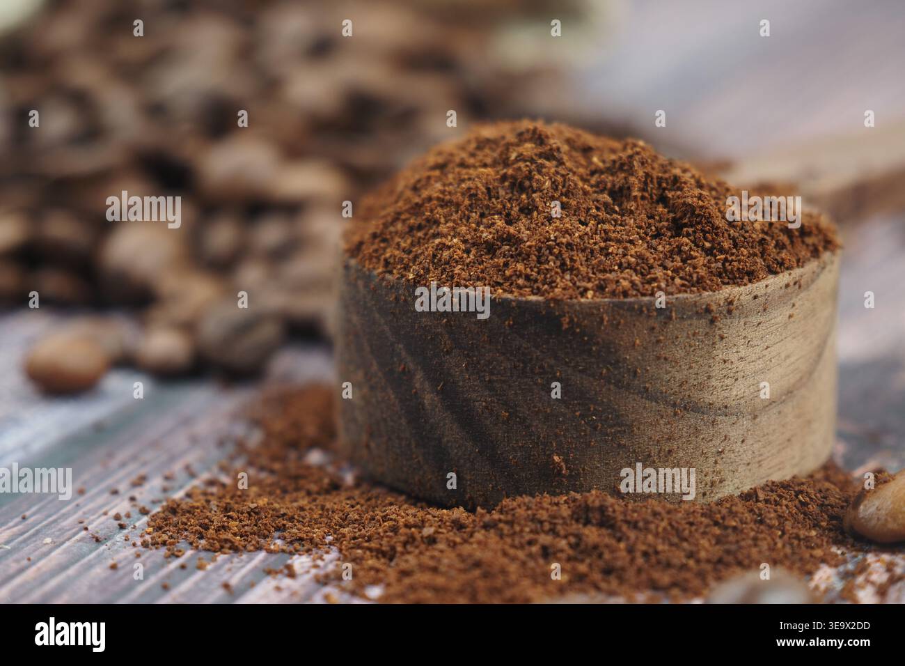Ground coffee in wooden scoop on rustic table surface Stock Photo