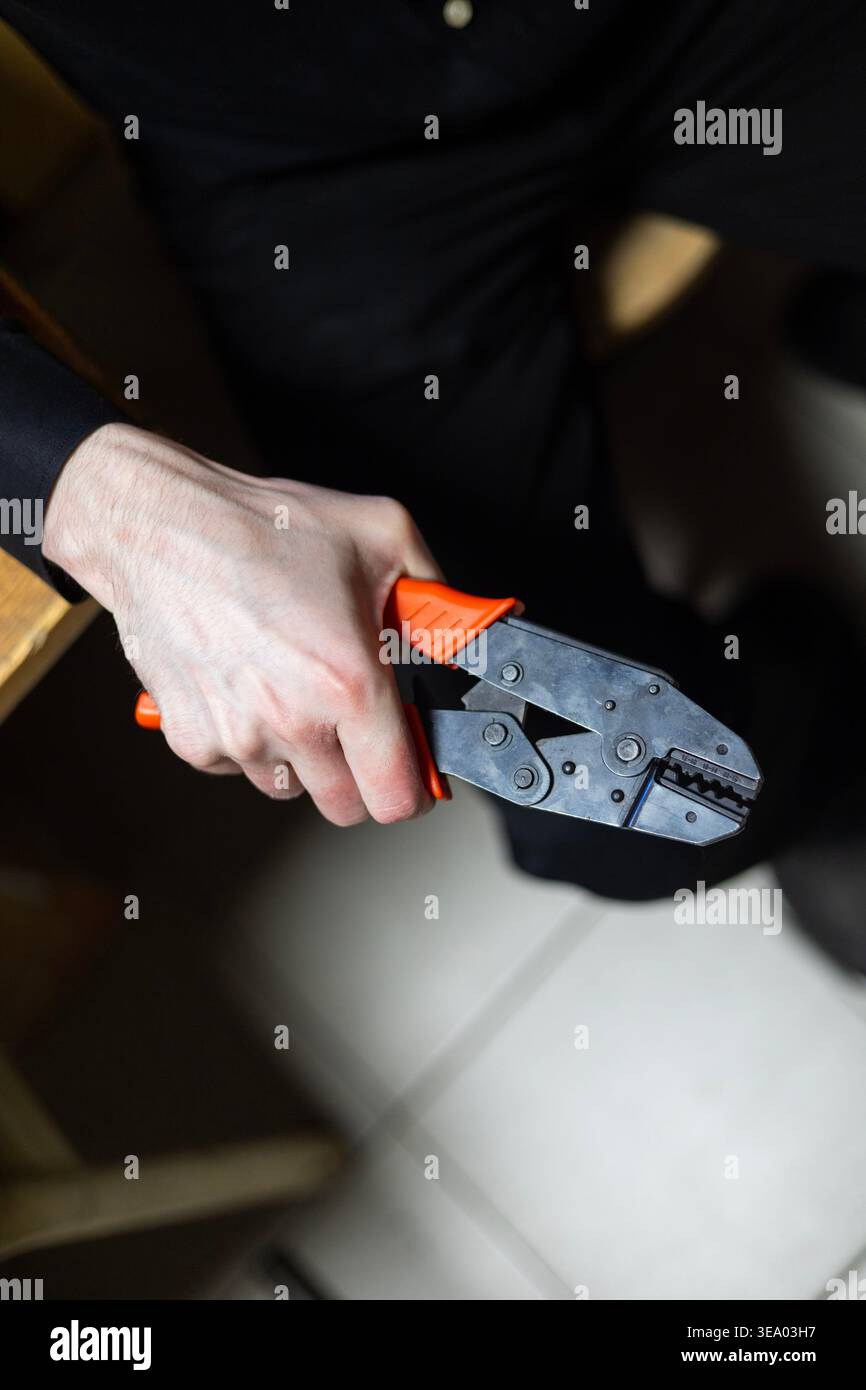 Technician holding a professional wire crimping tool. Stock Photo