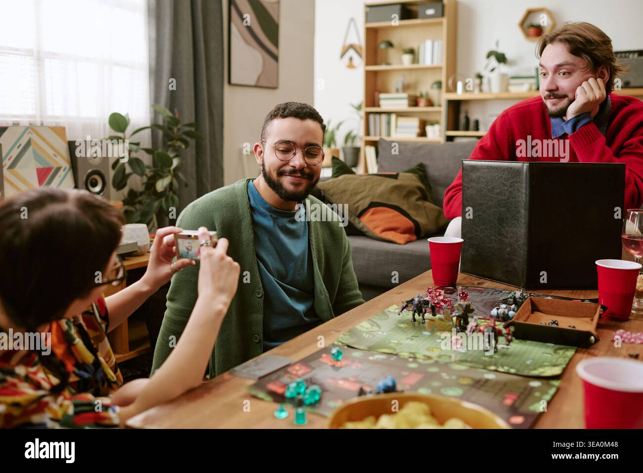 Diverse Friends Playing Tabletop Game during Social Gathering Stock Photo