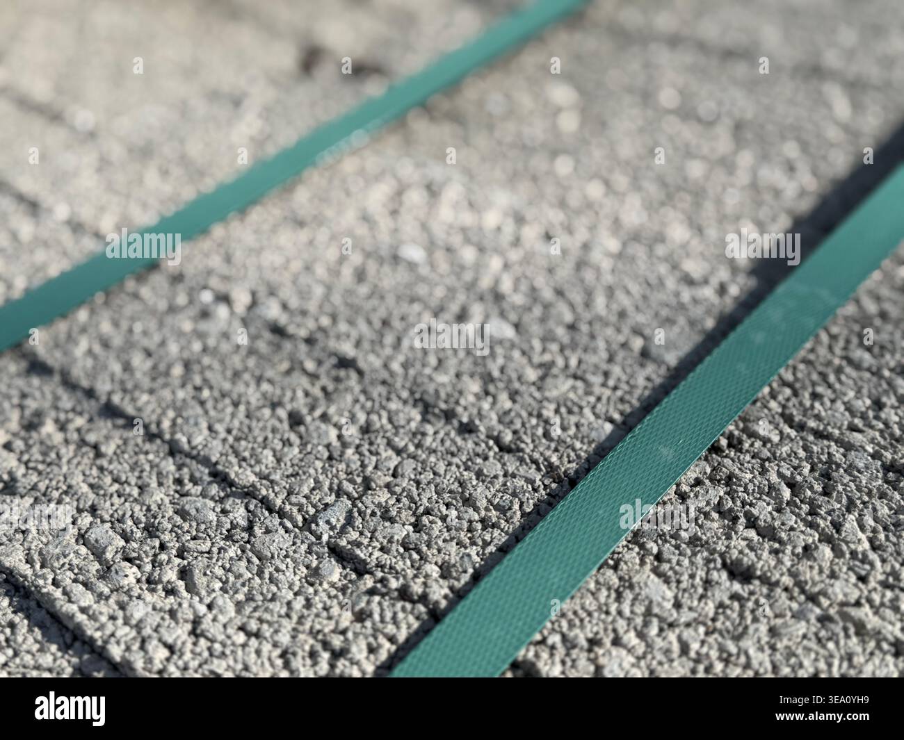 Close-up of textured concrete surface with green steel bands used for ...