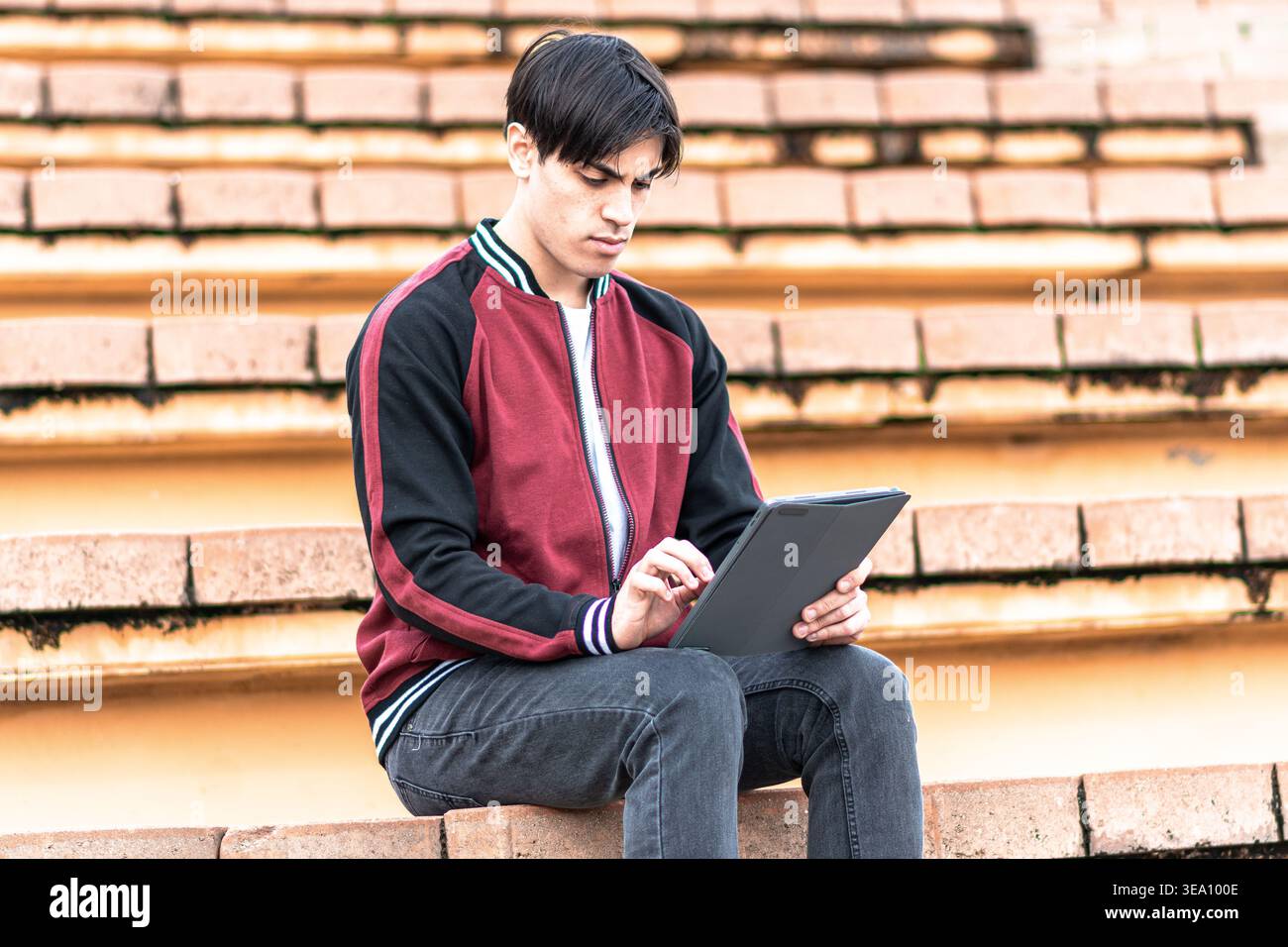 Young student learning outdoors using digital tablet Stock Photo