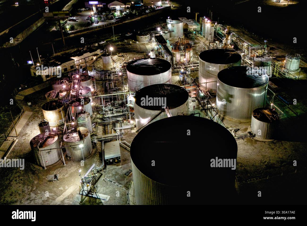 Illuminated oil refinery tank farm aerial night view Stock Photo - Alamy