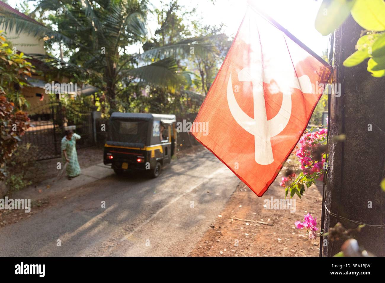 Communist symbols on the streets Kannur city in Kerala, India,  Hammer and Sickle on a red flag, flags hanging over the streets, auto rickshaw, tuktuk Stock Photo
