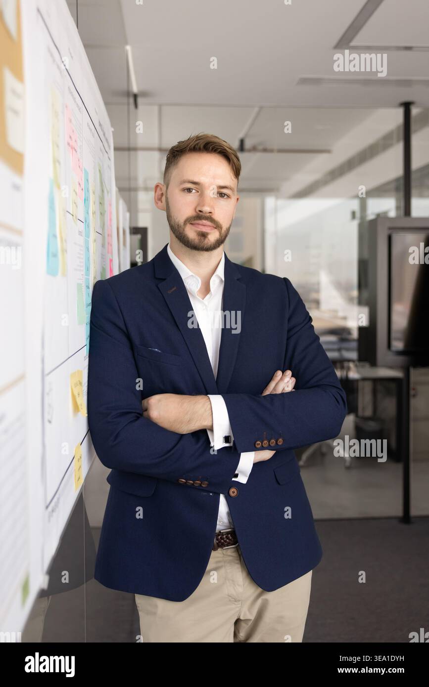 Confident young businessman standing in modern office Stock Photo