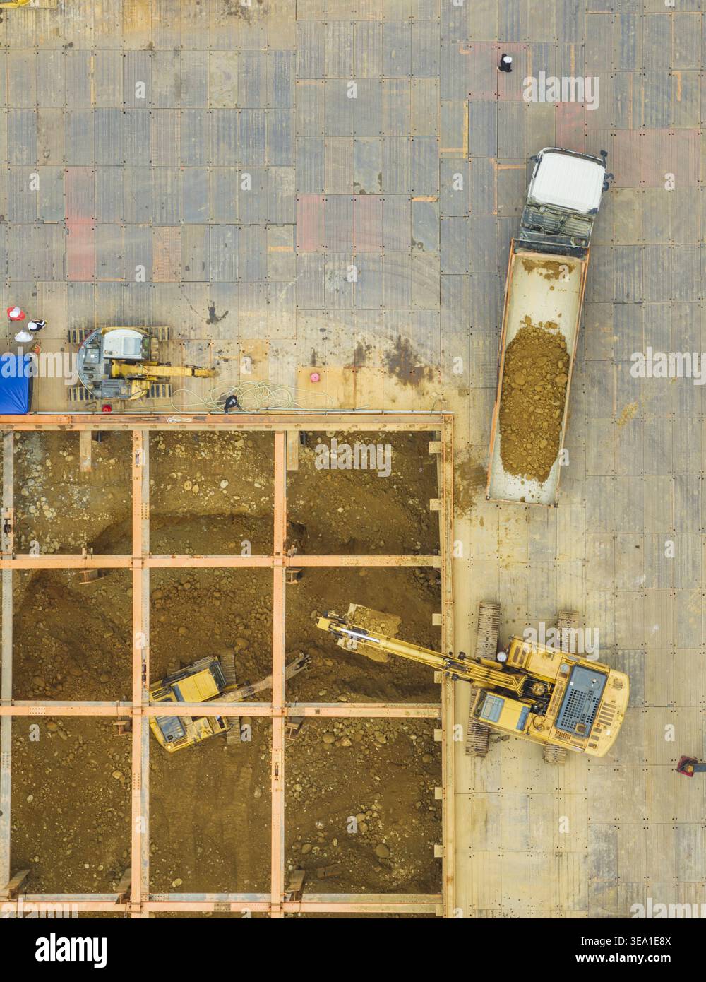 Aerial view of excavators working on building foundation engineering with a dump truck, steel beams and workers on a construction site in Taiwan. Stock Photo