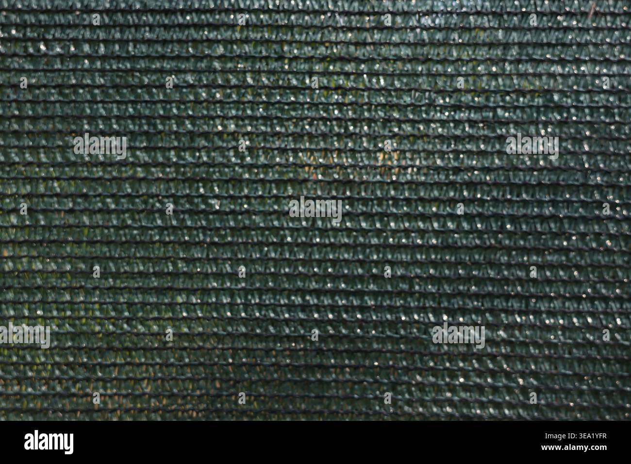 Each thread forms a uniform, repeating pattern. The surface reflects light subtly, creating a textured glow Stock Photo