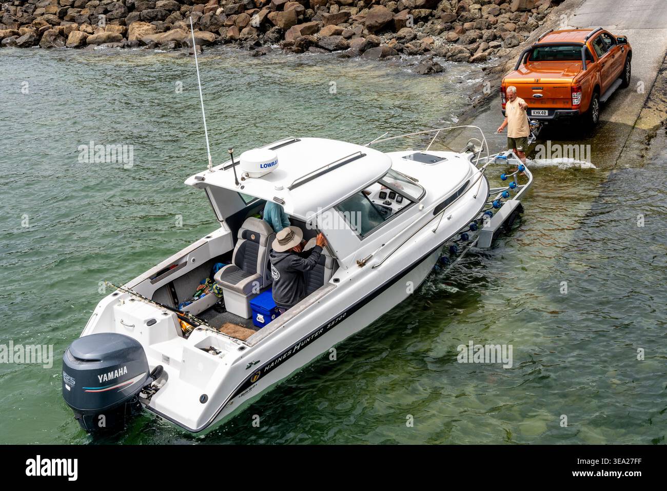 A Fishing Boat Is Towed Up A Jetty at Opononi, Northland, New Zealand. Stock Photo