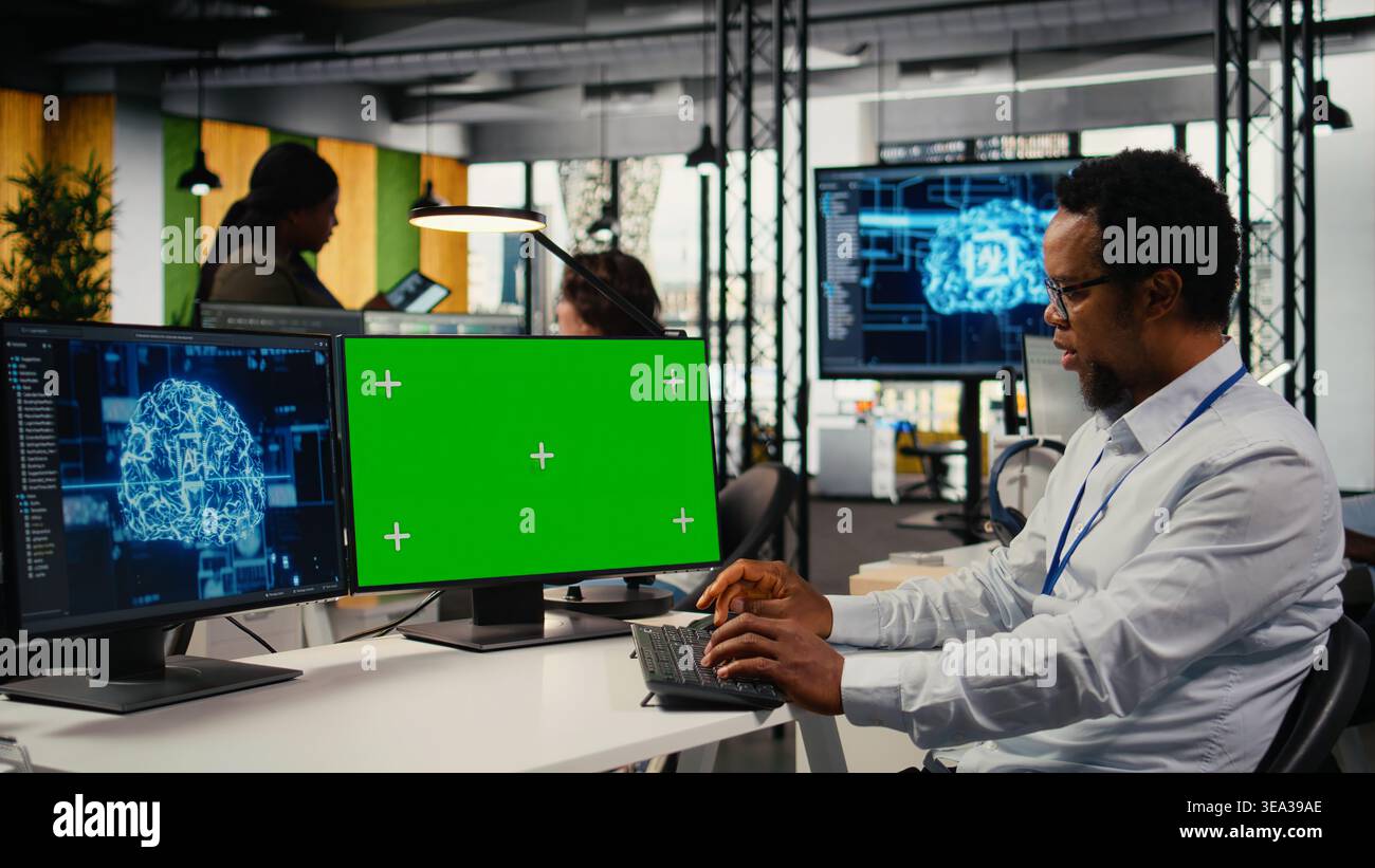 Green screen mockup PC used by data scientist in office automating workflows with artificial intelligence. IT worker refines deep learning models on chroma key computer for faster processing, camera A Stock Photo