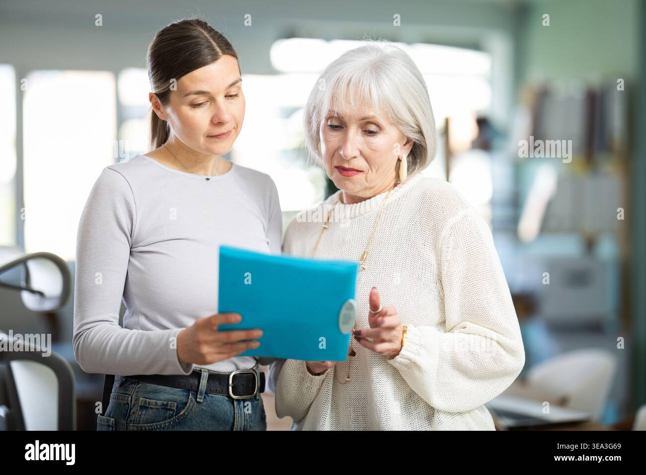 Woman shows elderly colleague documents Stock Photo