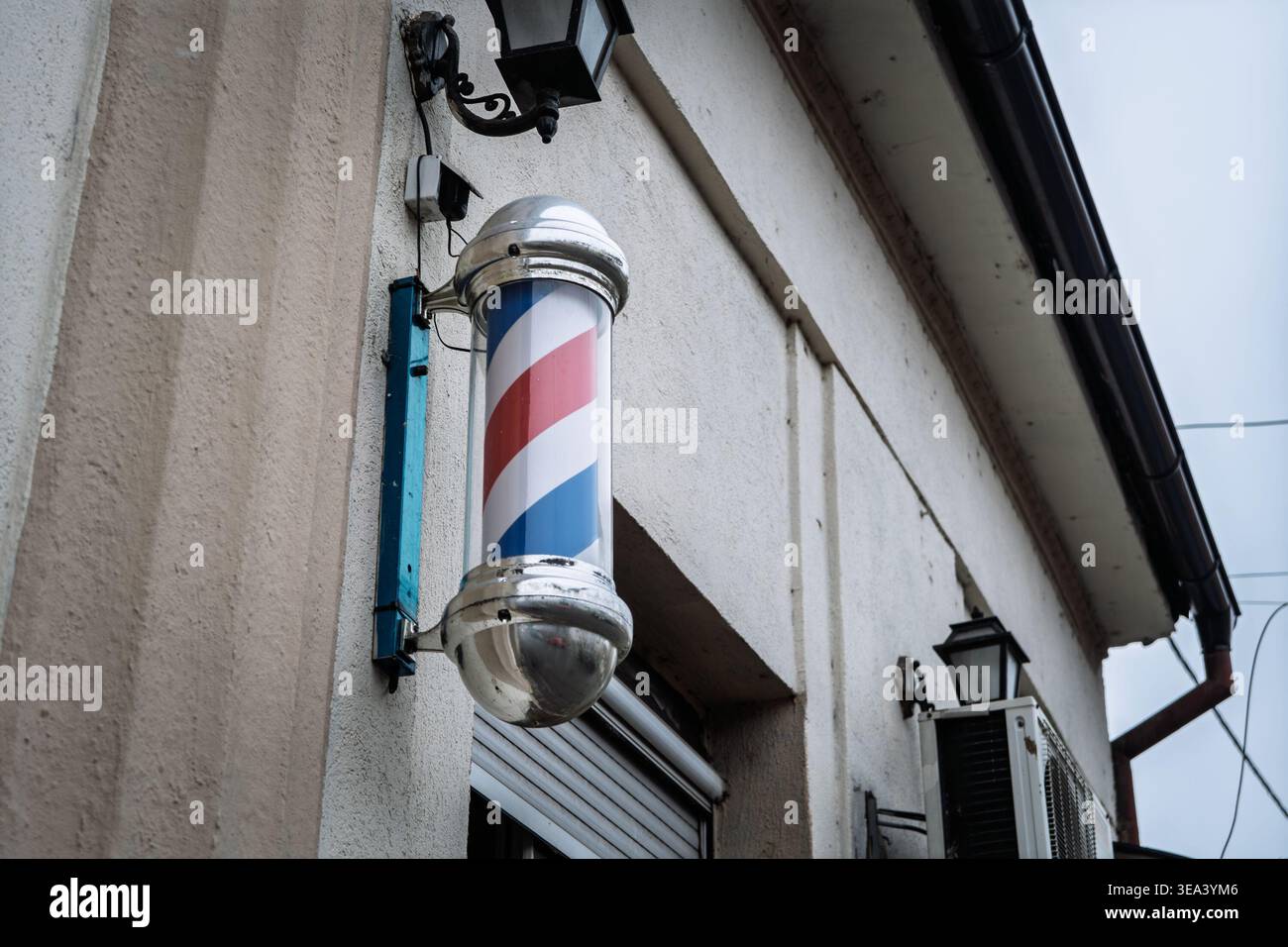 Close view of a classic red, white and blue barber pole mounted outside ...