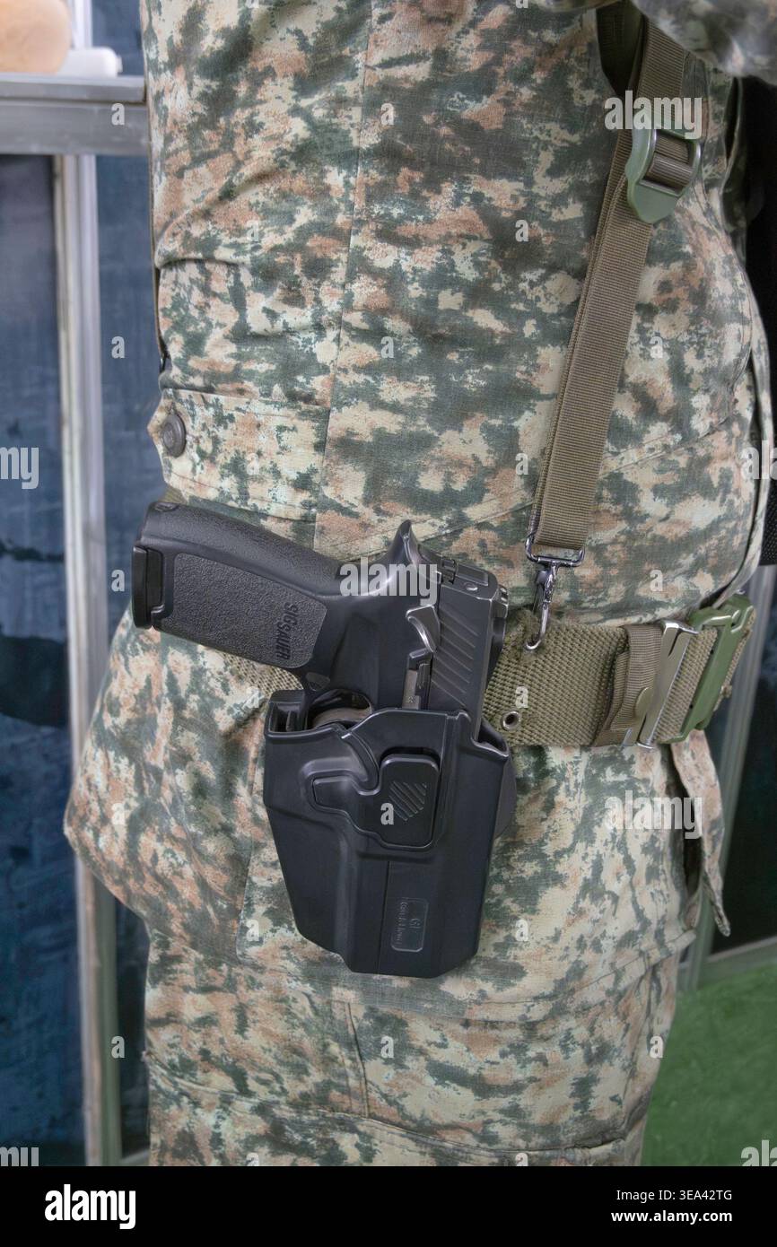 Military Sig Sauer handgun in holster on soldiers belt Stock Photo