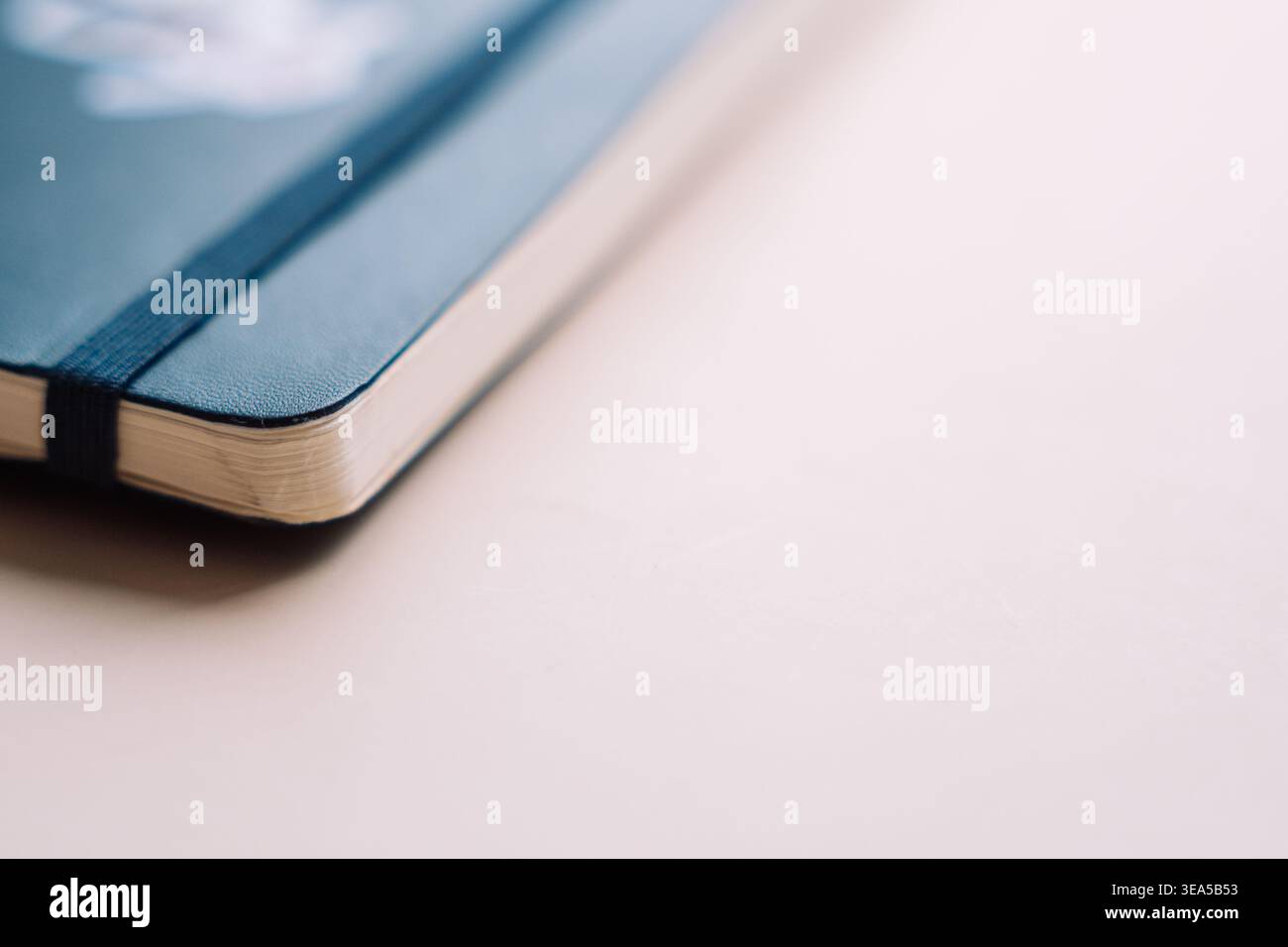 Blue notebook corner on soft beige background with copy space Stock Photo