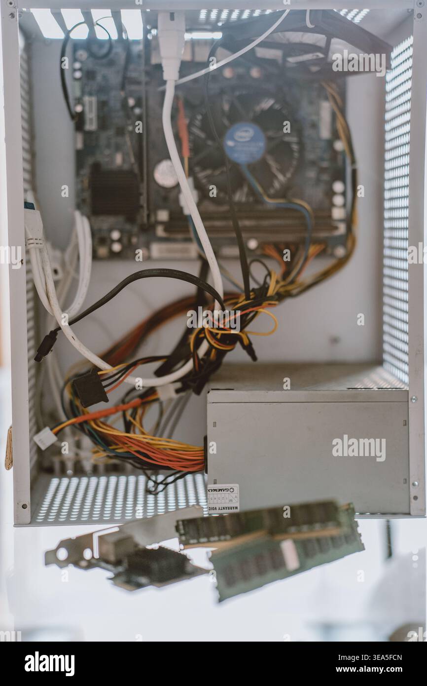 Inside a computer case with motherboard, cables, RAM modules, and power supply unit — open chassis Stock Photo