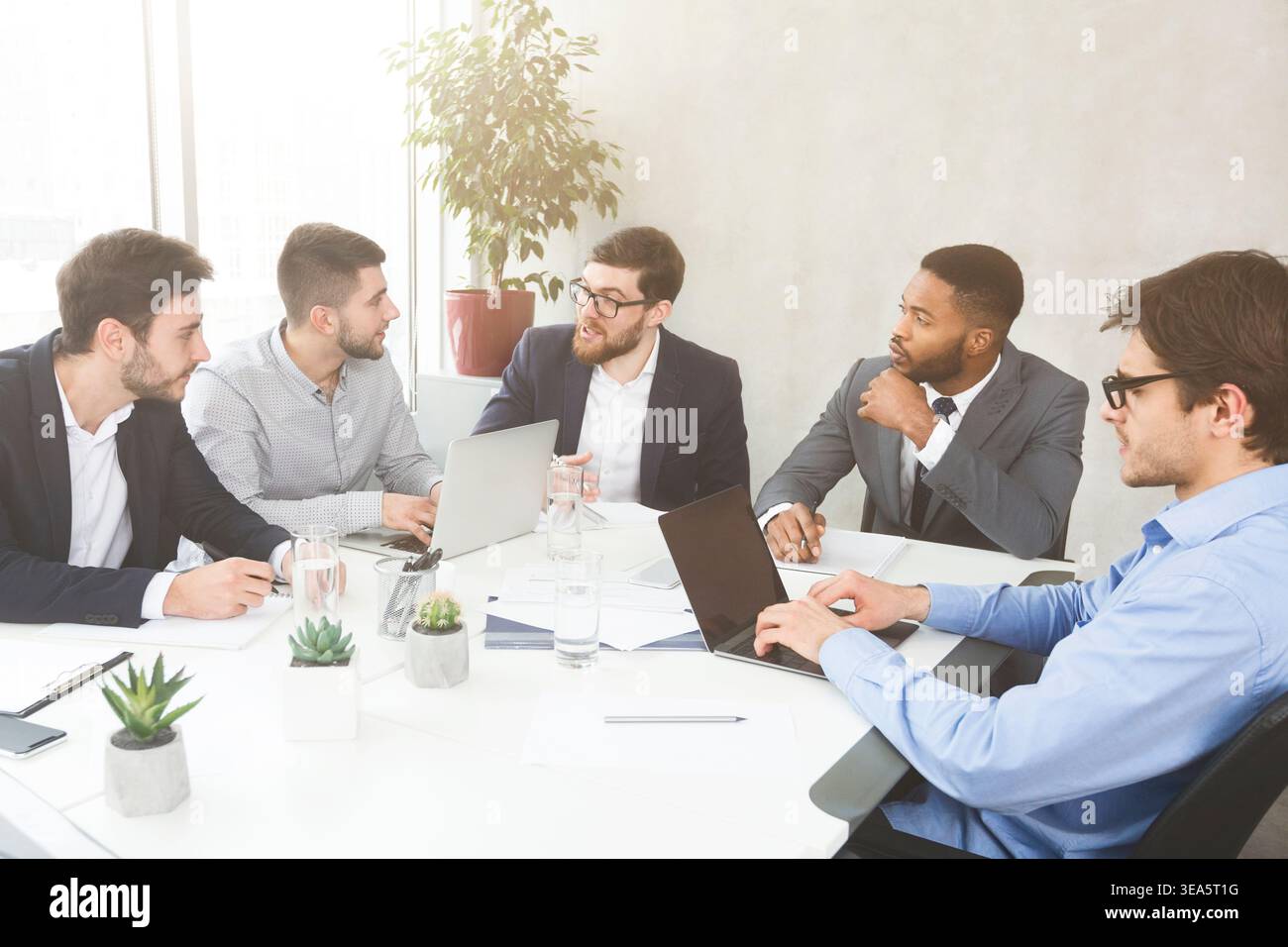 Businessmen having group meeting, discussing new project Stock Photo