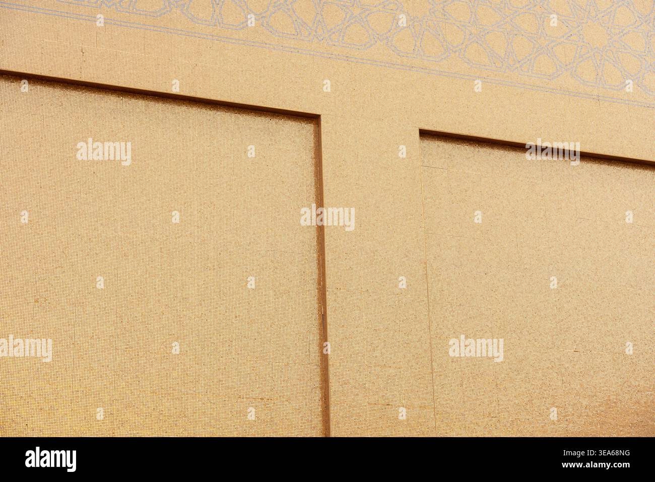 Katara Cultural Village, Doha, Qatar - December 23, 2025: A close-up shot of the golden-textured wall at the Golden Mosque in Katara. Stock Photo