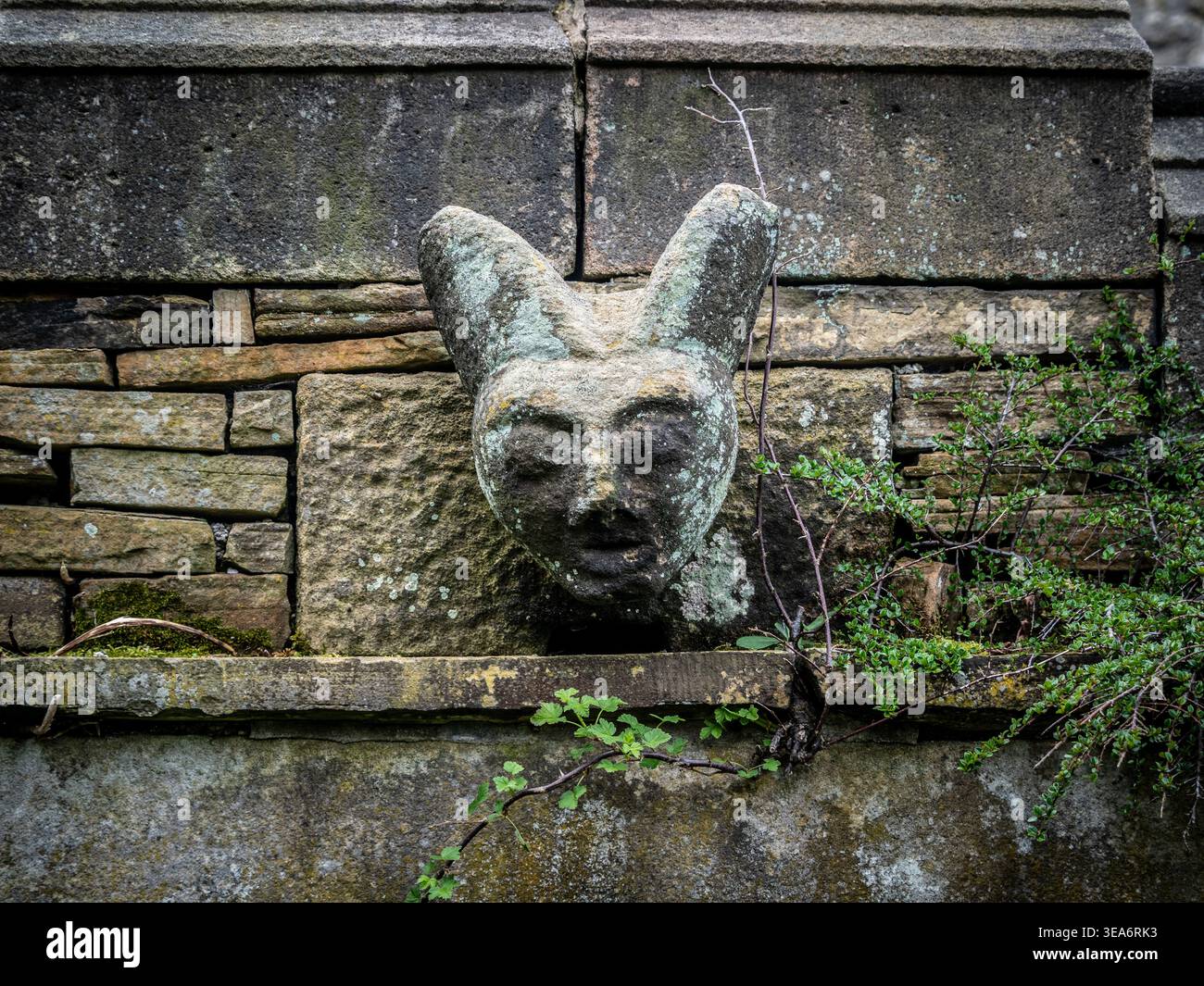 Carved stone grotesque above the doorway in the graveyard of St Michael’s Church, Hathersage, Derbyshire, England, UK Stock Photo