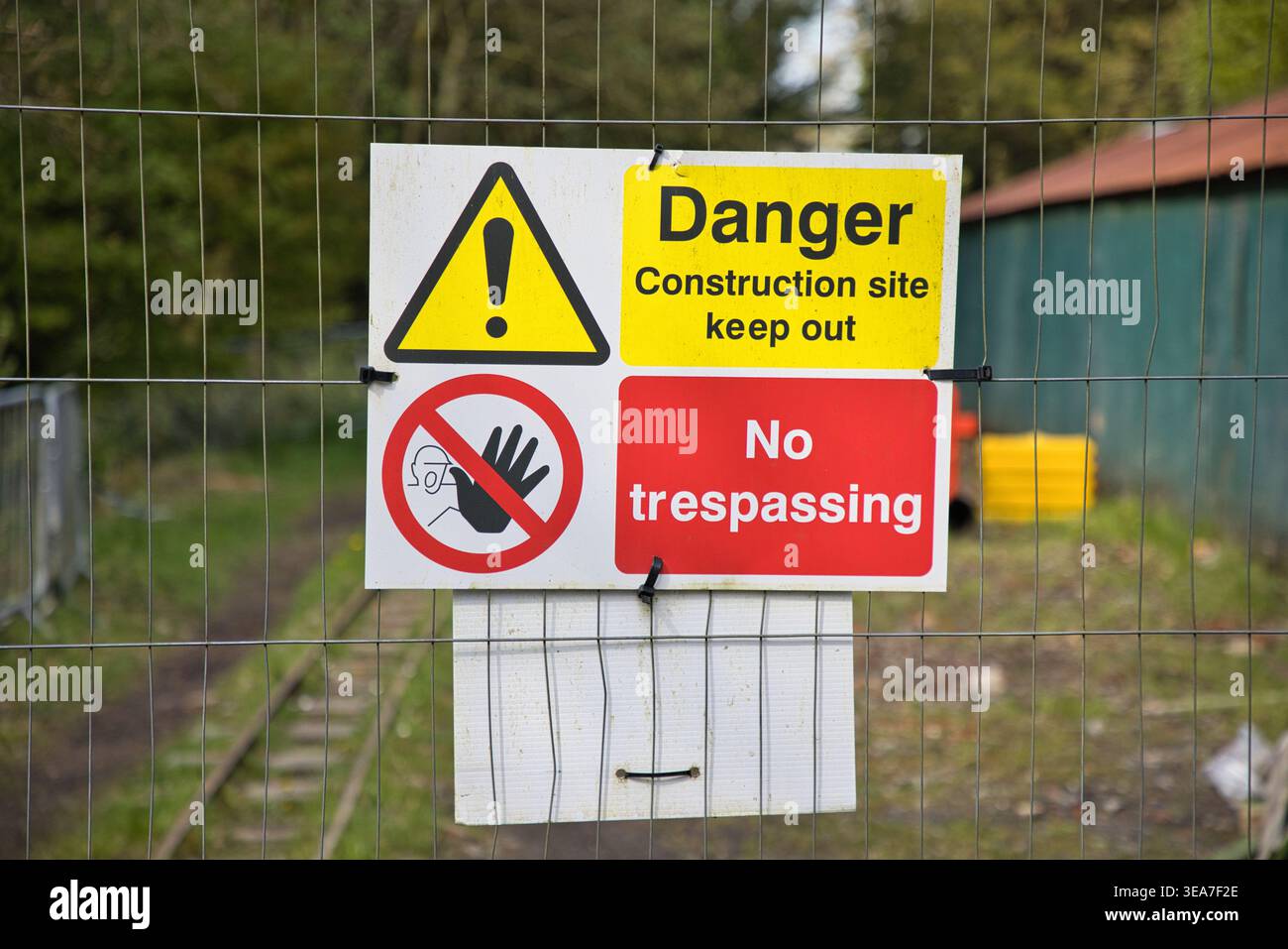 Construction Site Safety Warning Sign on Wire Perimeter Fence. Stock Photo