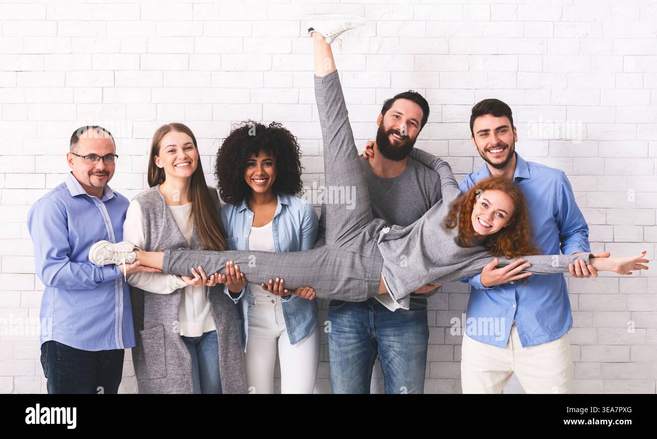 Joyful Multi-Ethnic Colleagues Having Fun, Posing Over White Brick Wall Background Stock Photo