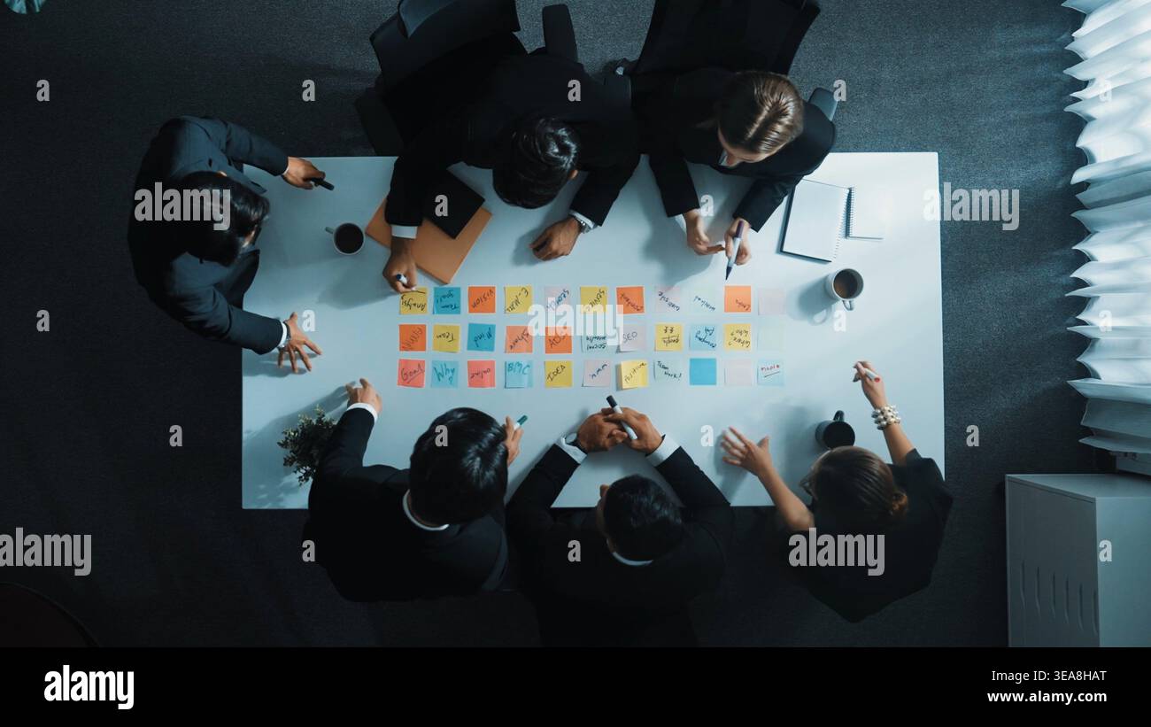 Top down aerial view startup team sharing marketing idea by using sticky notes. Professional diverse business group discuss brainstorm and planning Stock Photo