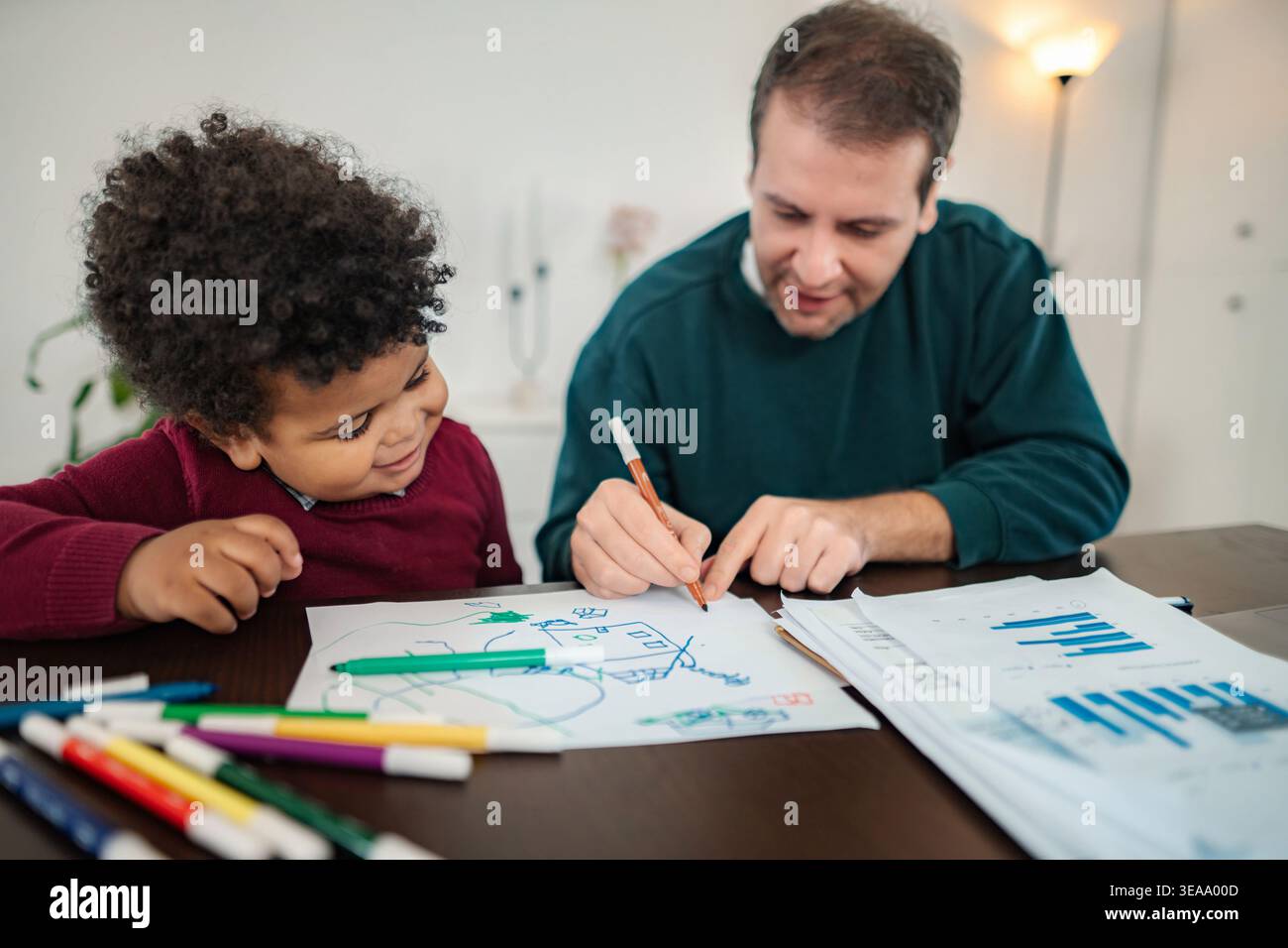 Father son bonding drawing together at home Stock Photo