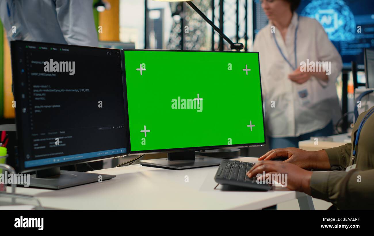 Green screen computer used by admin in office doing software development to launch new features. Mockup PC used by woman in startup company writing computer programs, doing code, camera B Stock Photo