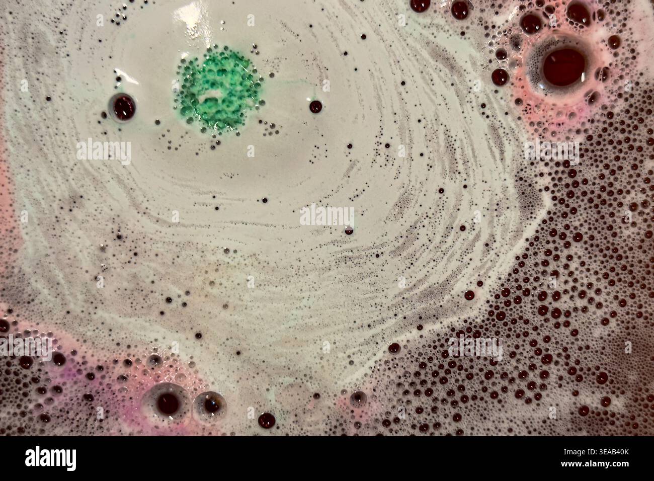 Colorful foam and bubbles produced by bath bombs in water, creates an organic, textured background element resembling a nebula scene from outer space. Stock Photo