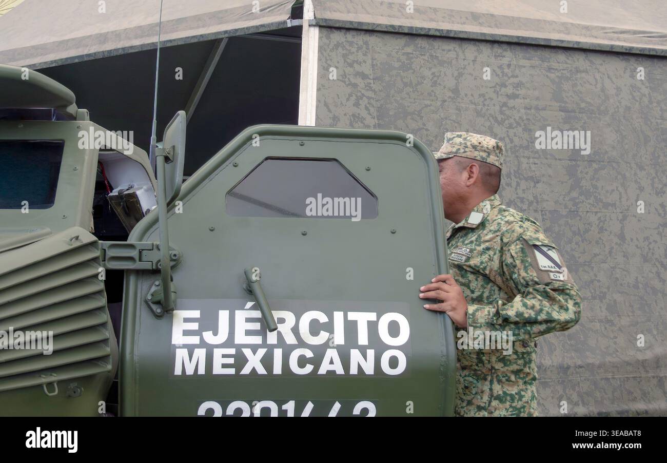 Anonymous Mexican soldier holding open door of armoured military vehicle with Ejercito Mexicano signage Stock Photo