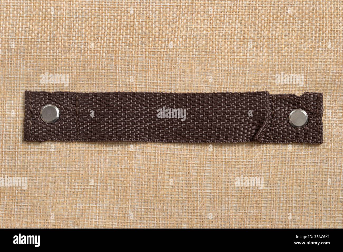 Brown fabric handle on beige canvas background closeup Stock Photo
