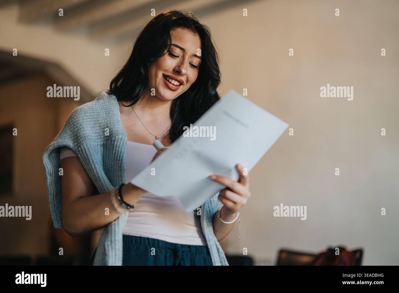 Smiling student reading notes in a classroom preparing for a presentation Stock Photo