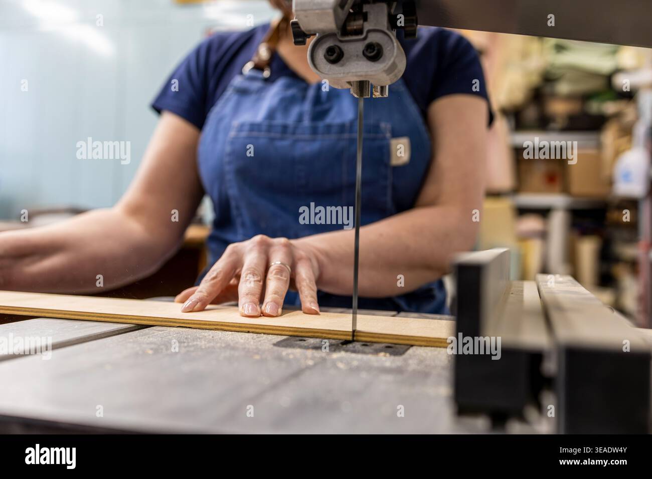 Woman Operating Woodworking Machine in Carpentry Studio Stock Photo