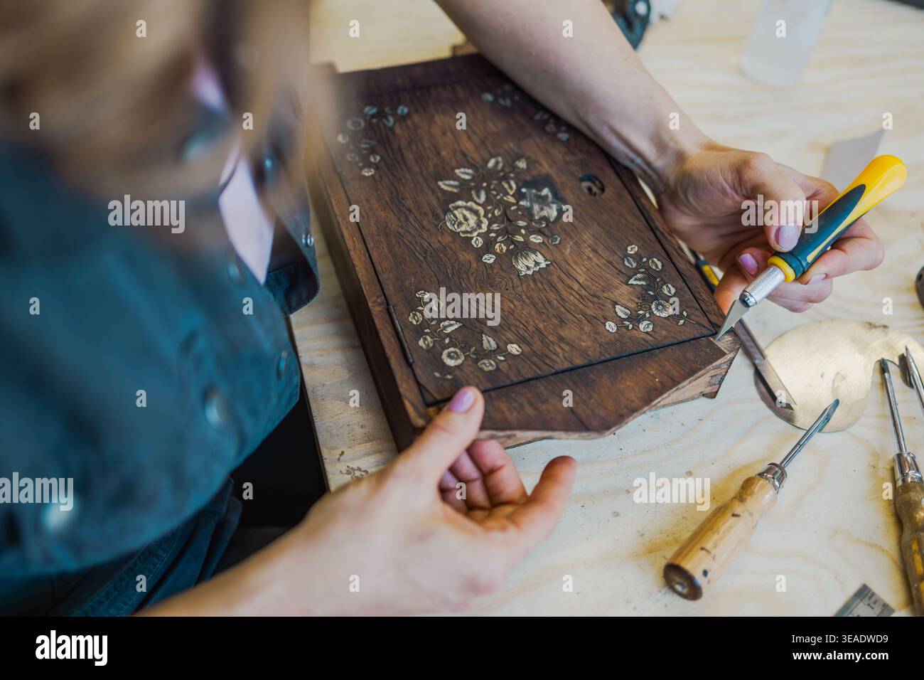 Restoring Decorated Wooden Box with Hand Tools on Workbench Stock Photo