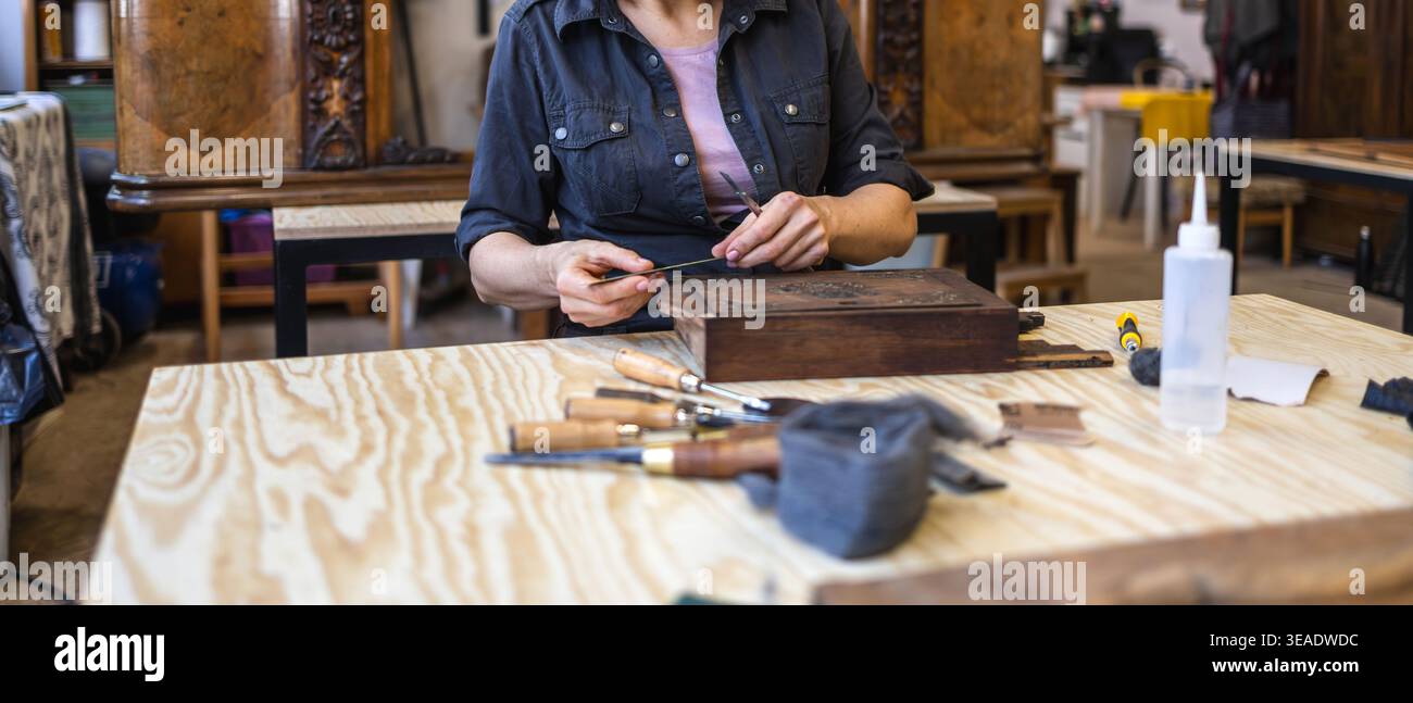 Restoring Decorated Wooden Box with Hand Tools on Workbench Stock Photo