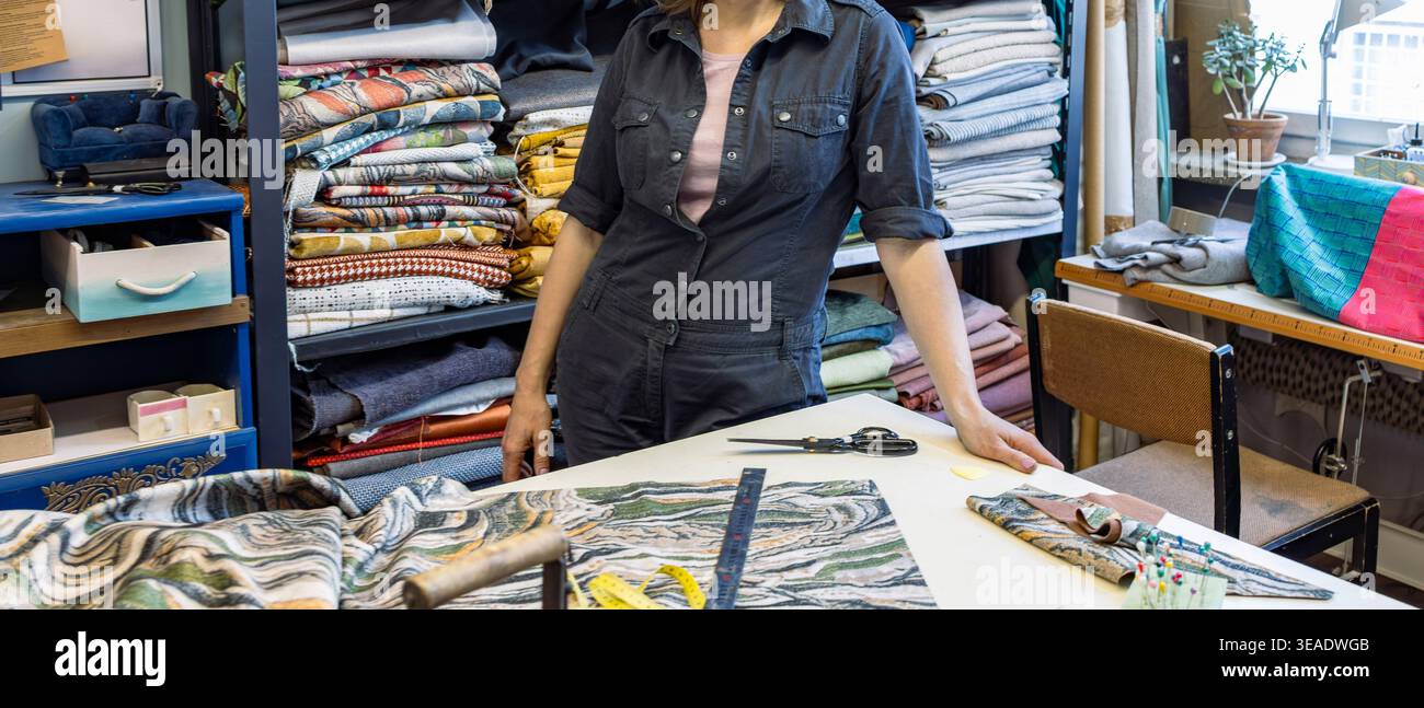 Seamstress working with fabrics in a tailor's workshop Stock Photo