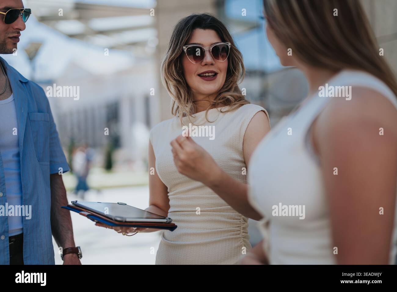 Young professionals having a business meeting outdoors while discussing documents on a tablet Stock Photo