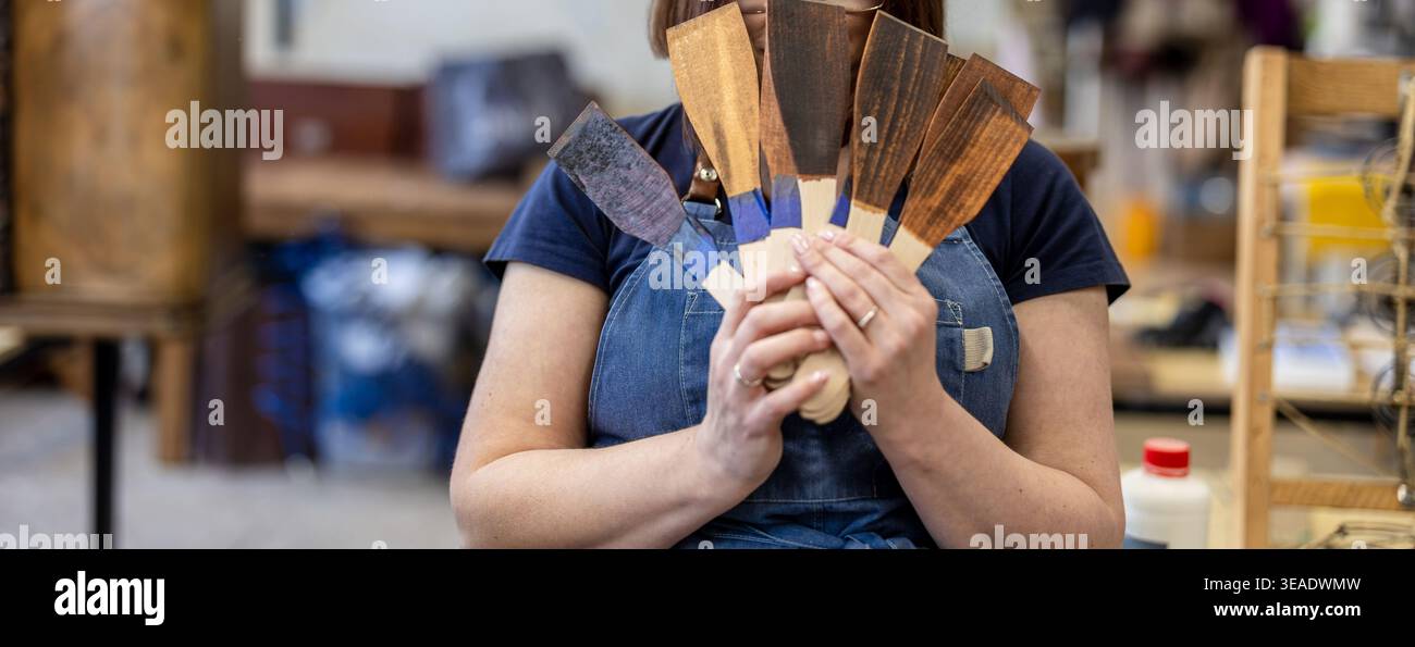 Woman Holding Wood Stain Color Samples in Carpentry Workshop Stock Photo
