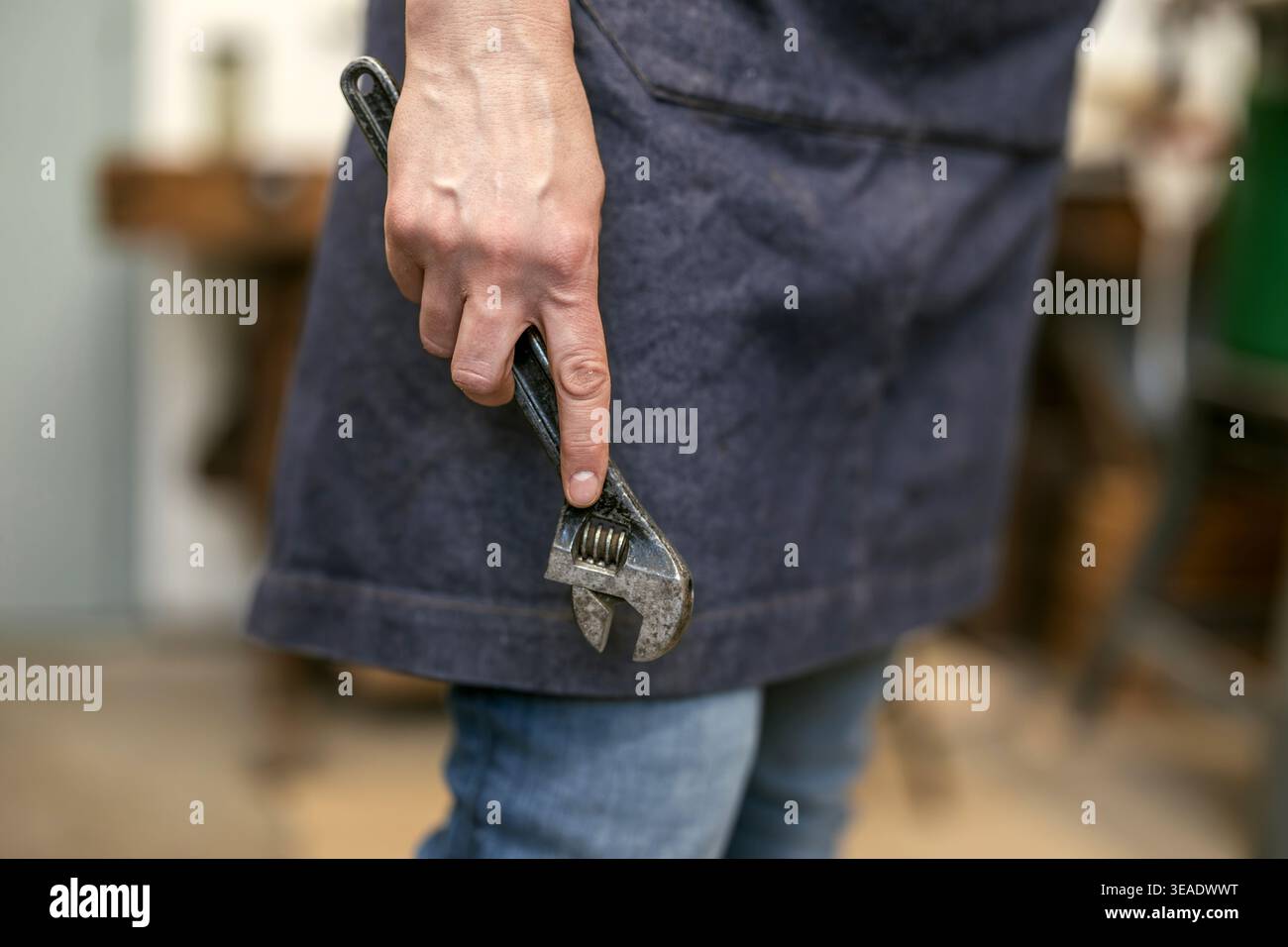 Carpenter Holding Wrench Tool in Workshop Stock Photo