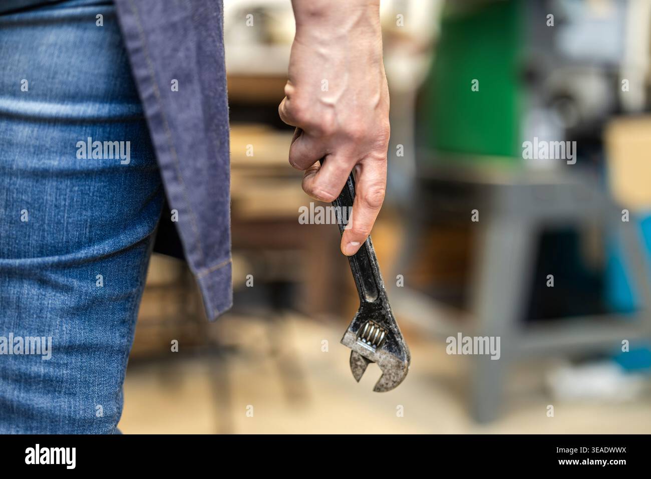 Carpenter Holding Wrench Tool in Workshop Stock Photo