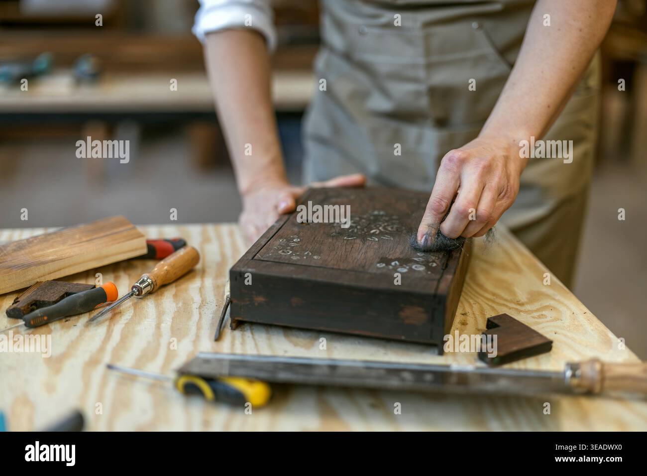 Restoring Decorated Wooden Box with Hand Tools on Workbench Stock Photo