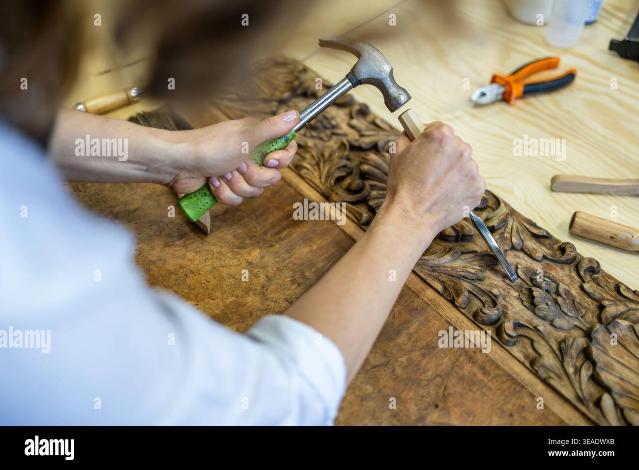 Restoring Ornate Wooden Panel with Carving Tools Stock Photo