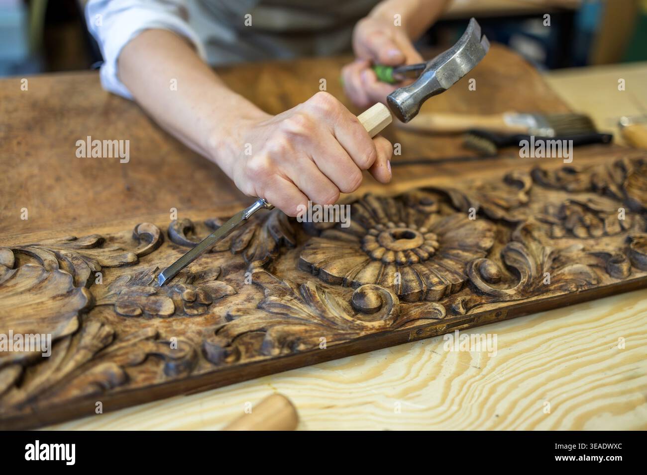 Restoring Ornate Wooden Panel with Carving Tools Stock Photo