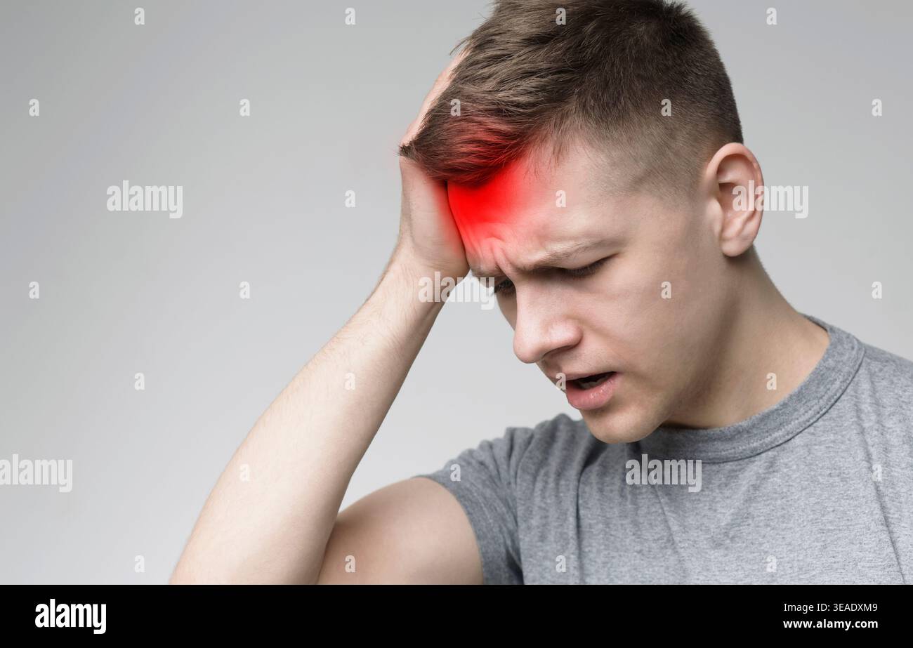 Frustrated handsome young man touching his head Stock Photo