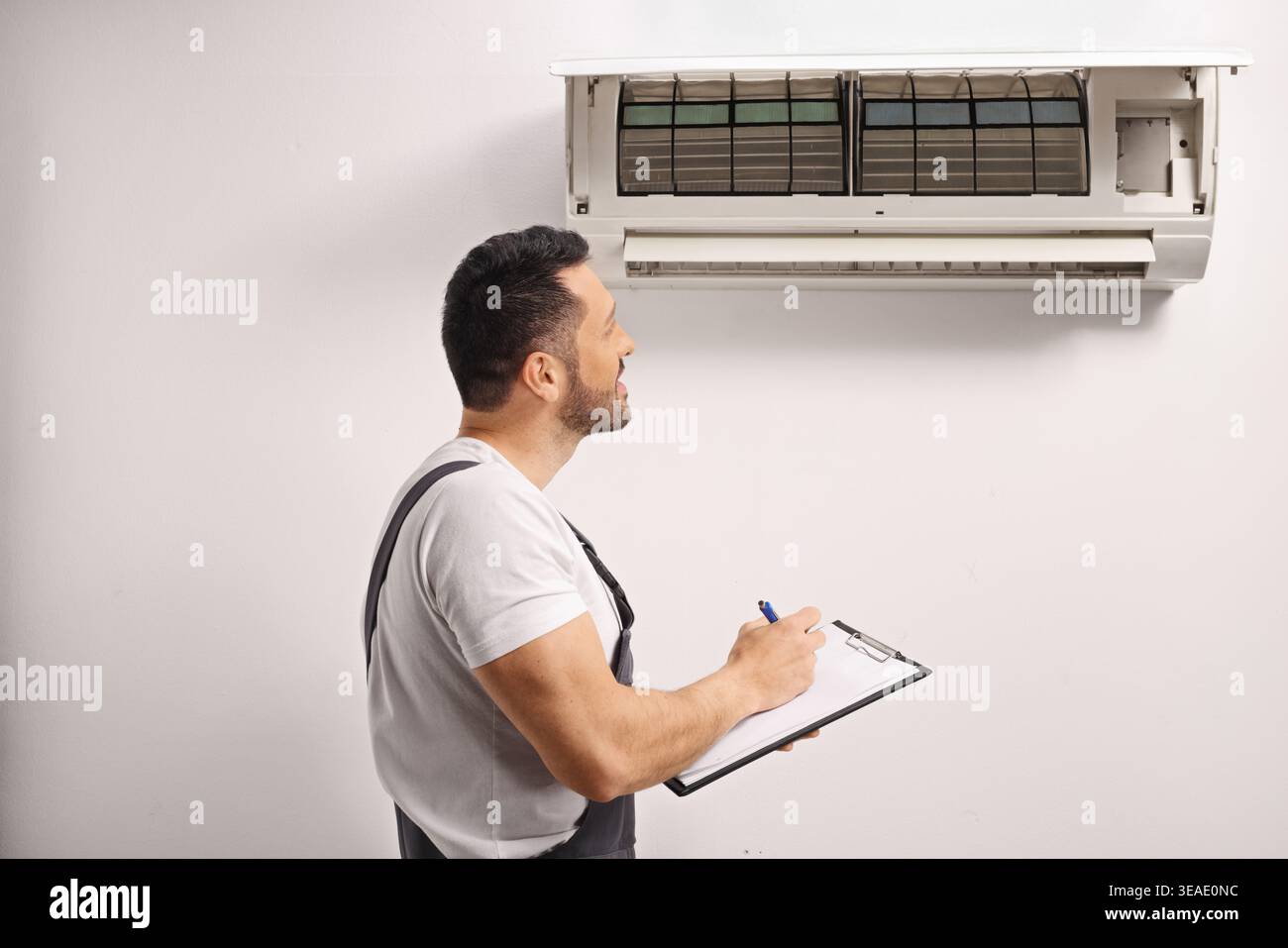 Air conditioner maintenance technician inspecting an indoor unit Stock Photo
