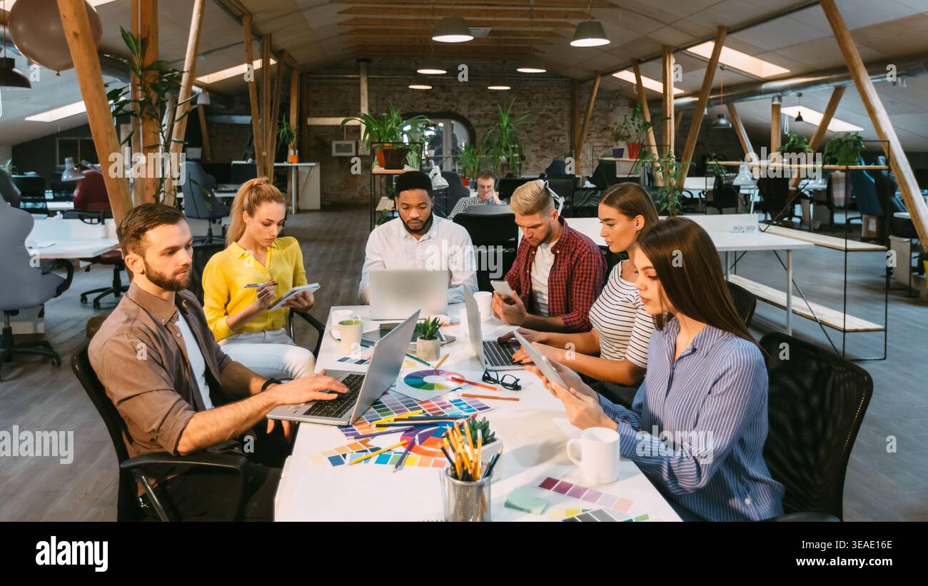 Concentrated designers working in office, using laptops Stock Photo
