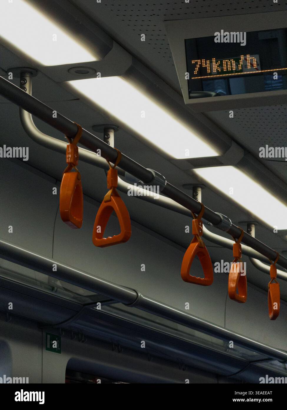 Close-up of passenger grab handles inside a metro train car, highlighting public transportation, safety, and daily urban commuting. - Smartphone Captured Stock Image