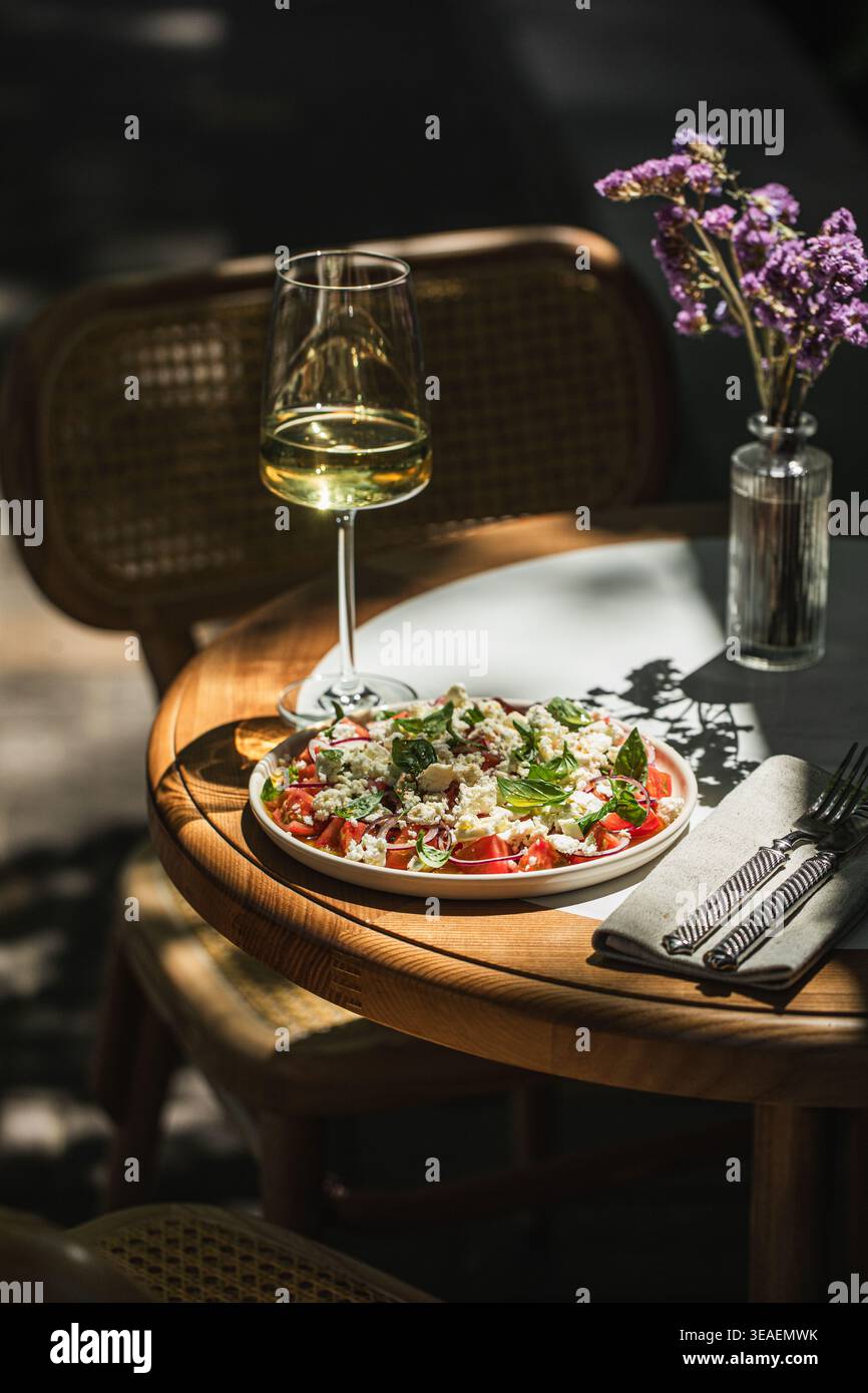 Mediterranean salad with wine on sunny table Stock Photo