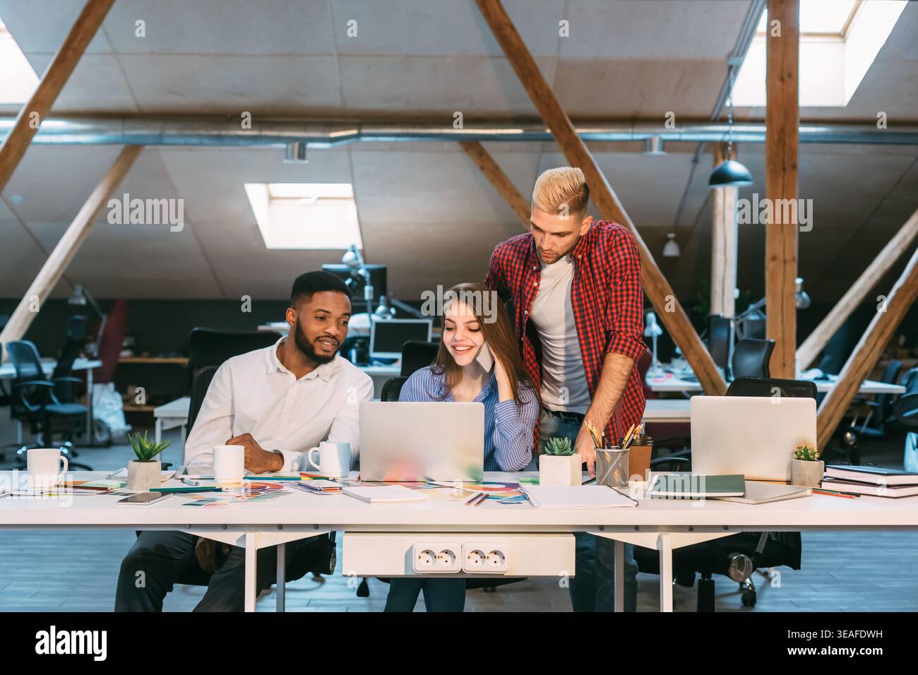 Group Collaborates on Project in Modern Workspace During Daytime Hours Stock Photo
