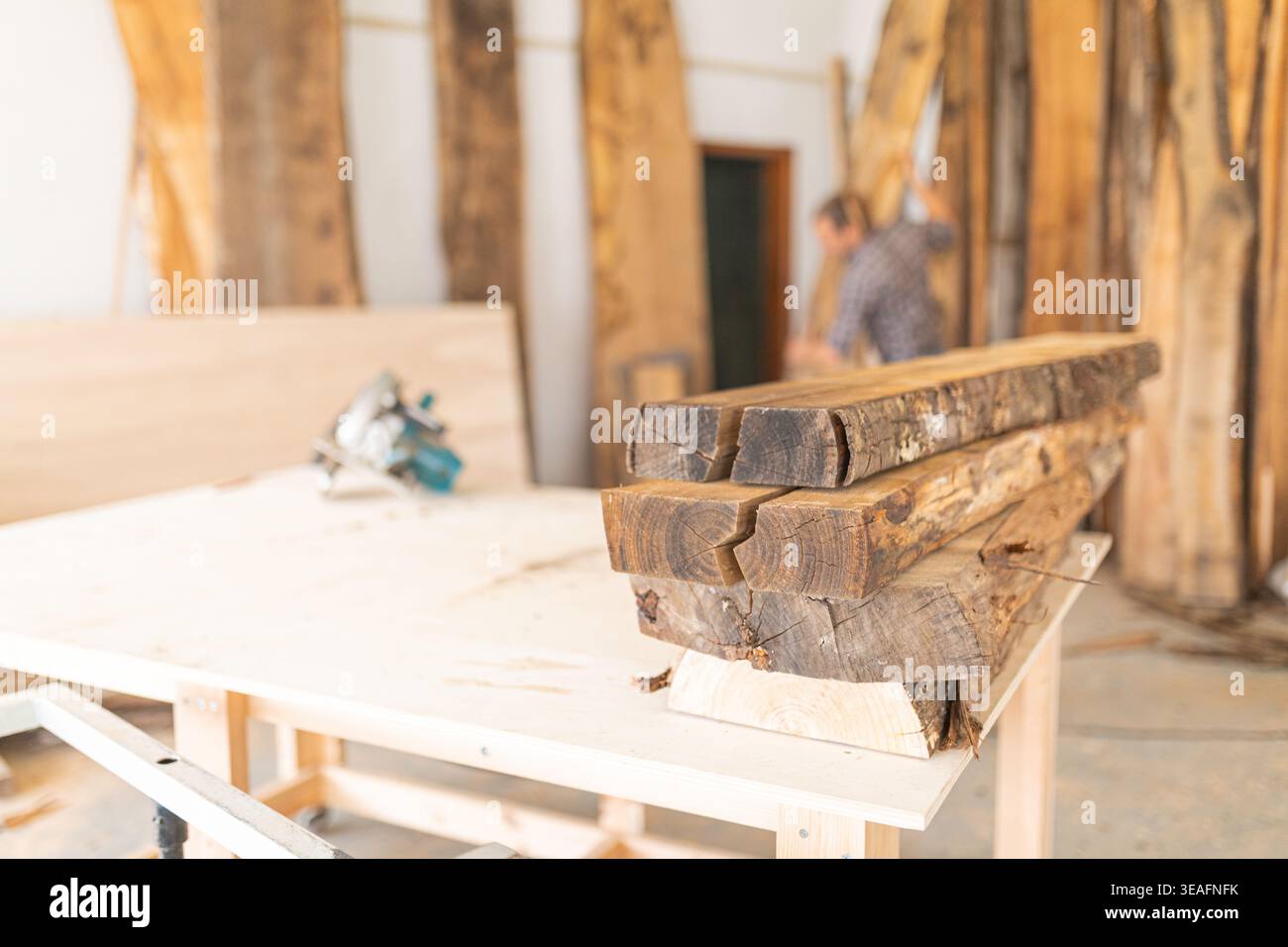 Wood slabs stacked on workbench in workshop Stock Photo