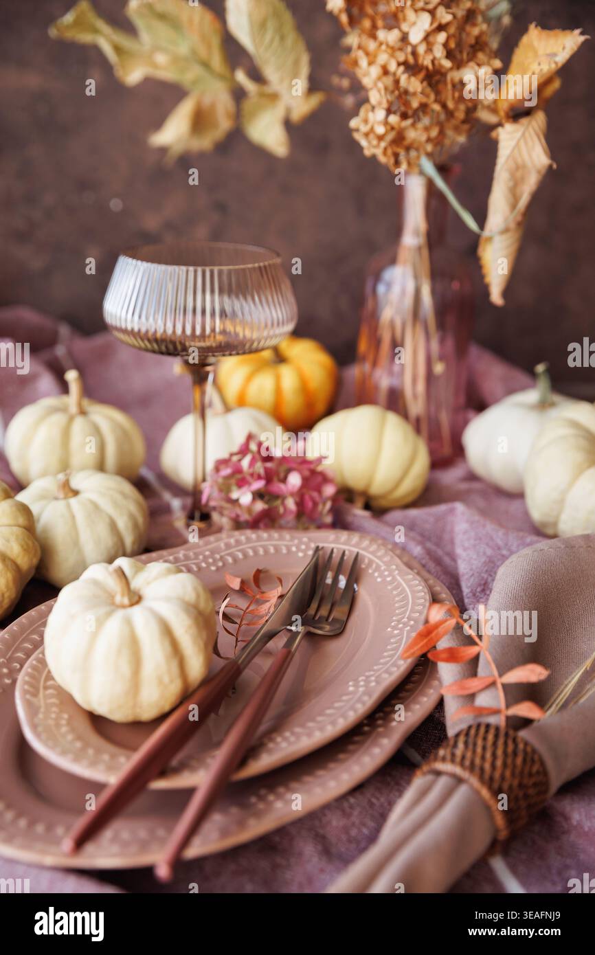 Fall-inspired dining table with pumpkins and elegant tableware Stock Photo